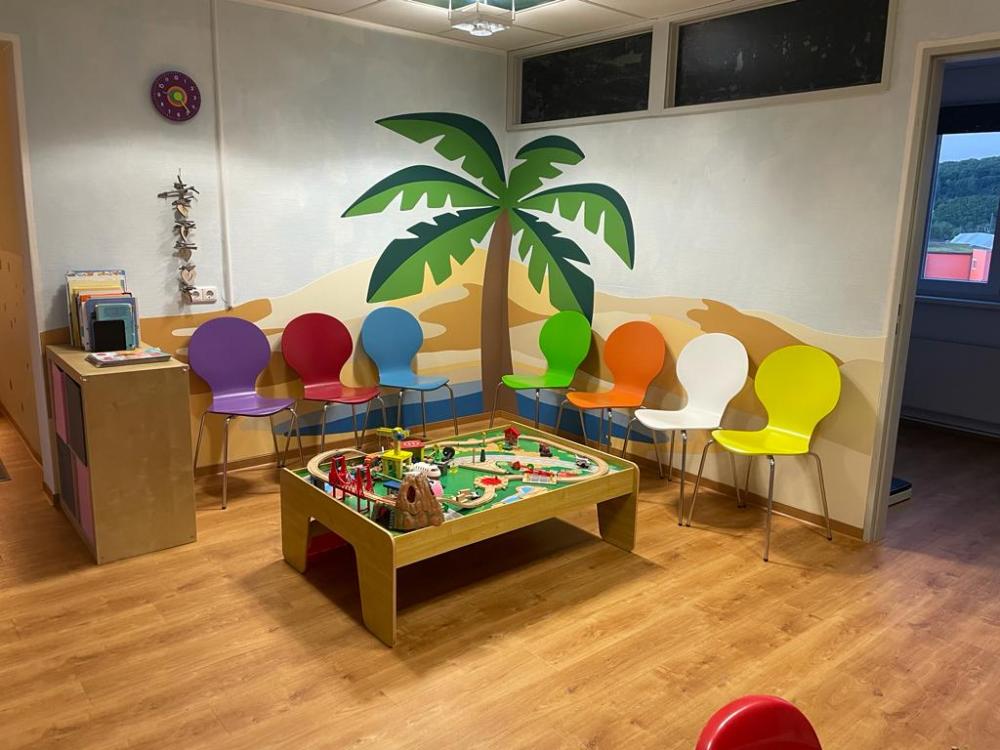 Wandschutz in der Sitzecke Kinderarztpraxis, mit Palmenmotiv