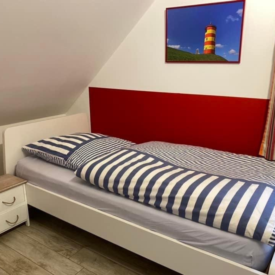 Wandschutz in rot hinter dem Bett