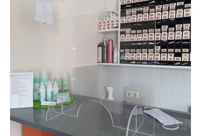 Verkaufstresen in einem Friseursalon mit einem aufgestellten Glasschutz von Wandschutz Nielsen.